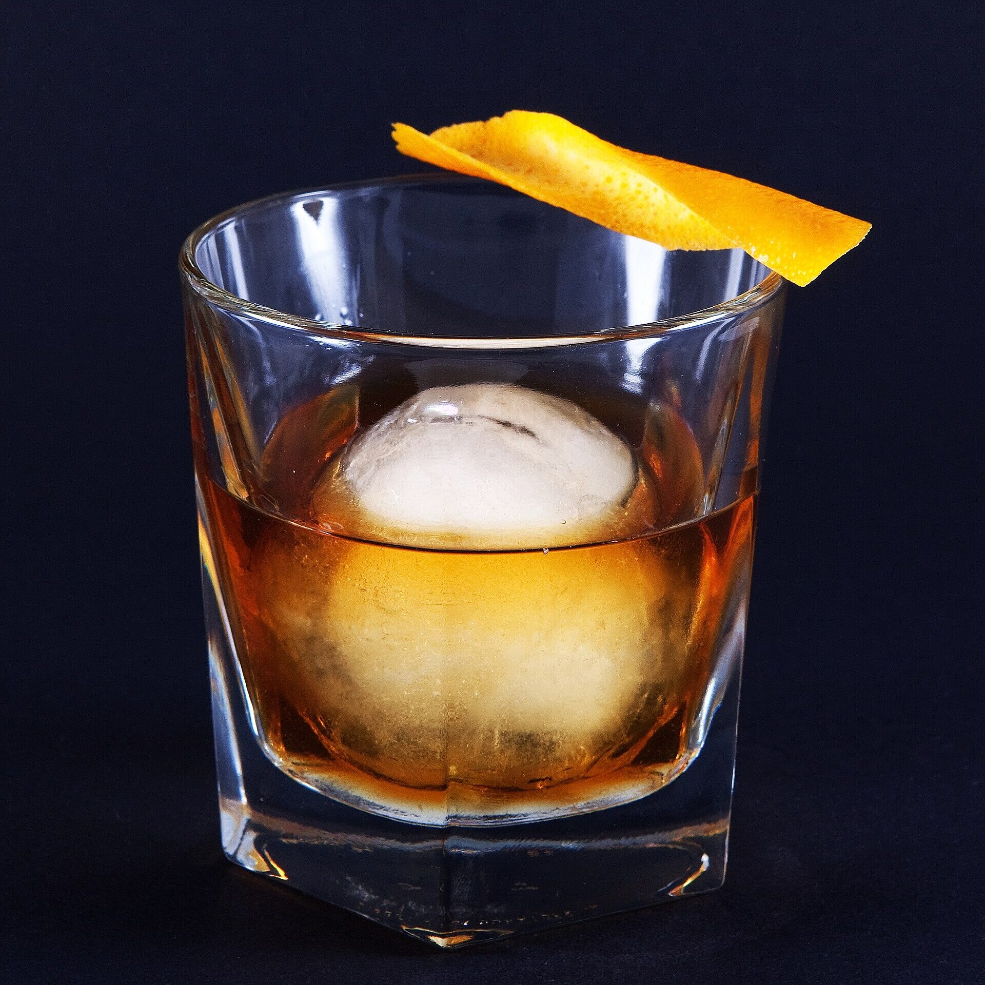 A Whiskey Old Fashioned cocktail with an orange twist